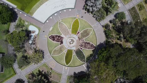 Drone-topdown-video-of-flower-arrangement-surrounded-by-trees-and-green-areas-and-ponds