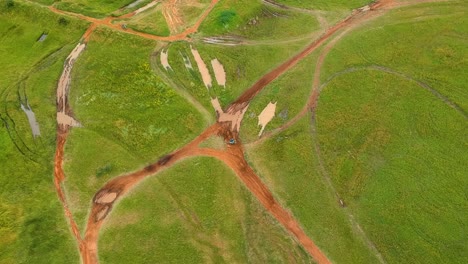 Drone-shot-of-dirtbikes-on-a-muddy-track,-top-down-drone-view