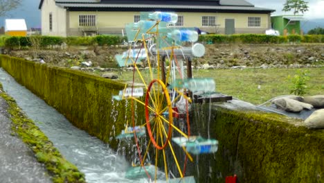 DIY-Wasserrad-Im-Bewässerungskanal,-Das-Sich-Im-Uhrzeigersinn-Dreht,-Um-Wasser-Zu-Holen
