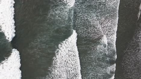Aerial-View-of-waves-crashing-onto-the-shore-at-Dominical-Beach-in-Costa-Rica,-Slow-Top-Down-Push-In