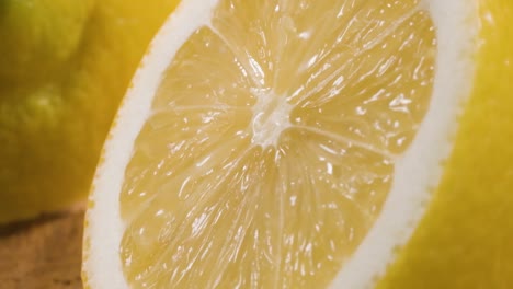 Makroaufnahme-Halbe-Zitrone,-Wasser-Fließt-In-Zeitlupe-über-Frische-Strukturierte-Oberfläche,-Saftige-Frucht