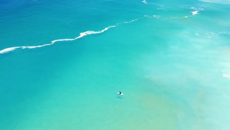 High-Angle-of-surfer-alone-in-ocean,-waiting-on-waves