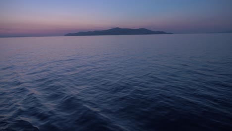 Das-Schiff-Verlässt-Den-Hafen-Von-Piräus-Bei-Einem-Wunderschönen-Sonnenuntergang,-Der-Ozean-Ist-Ruhig