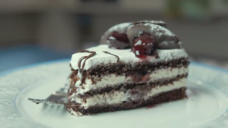 Slice-of-chocolate-cream-birthday-cake-on-plate-rotating