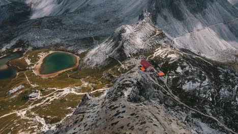 Wanderhütte-Drei-Zinhütte-An-Einem-Wunderschönen-Blauen-See-Im-Hochgebirge-Der-Dolomiten-Mit-Den-Steilen-Bergwänden-Der-Italienischen-Berge-Im-Hintergrund