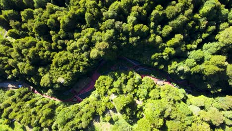 Aerial-truck-right-of-Termas-Geometricas-hot-spring-complex,-surrounded-by-dense-woodland-at-daytime,-Coñaripe,-Chile