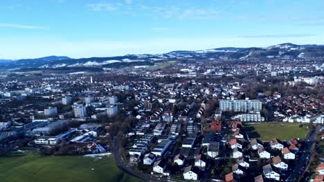 Peaceful-city-in-southern-Germany-with-chaotically-laid-out-houses-in-the-foreground,-snow-covered-hills-in-the-background