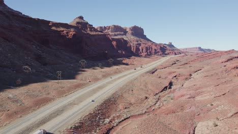 Drohne-Steigt-über-Die-Autobahn-Mit-Roten-Felsbergen-Im-Rücken,-Moab-Utah