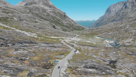 Un-Coche-Conduce-A-Través-De-Las-Montañas-Noruegas-En-Un-Día-Soleado-Y-Bonito