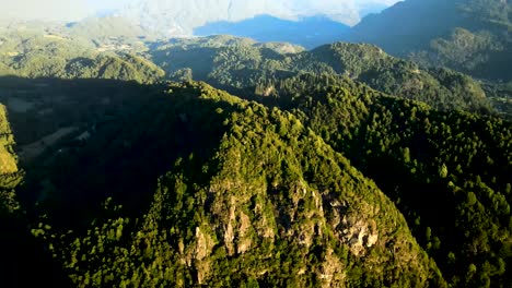 Aerial-pan-right-of-Andean-mountains-covered-in-green-dense-woods-at-golden-hour-in-El-Leon-viewpoint,-Chile