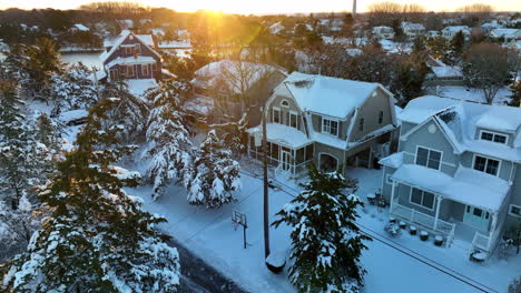 Snow-covered-homes-and-trees-at-sunrise