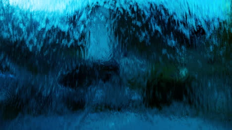 Abstract-view-of-deep-blue-water-flowing-down-over-glass-in-front-of-camera-view-in-village-in-Europe,-wide-view