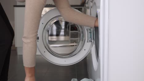 Frau,-Die-Hellblaue-Decke-In-Die-Waschmaschine-Legt,-Hausarbeitskonzept,-Küchenhintergrund