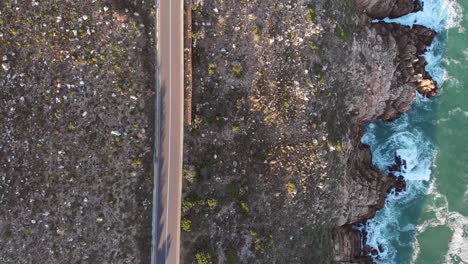 Top-down-drone-shot-of-a-road-next-to-the-beach