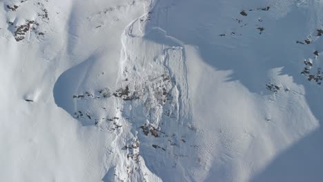 Luftaufnahme-Weg-Von-Einem-Schneerutsch,-Sonnig,-Wintertag,-In-Österreich---Rückseite,-Drohnenaufnahme
