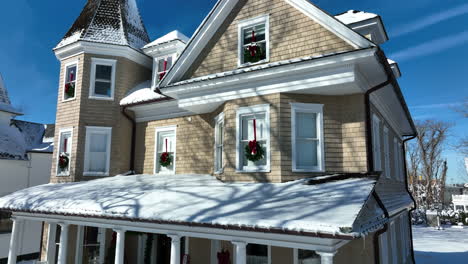 Beautiful-Victorian-home-with-Christmas-wreath-decoration-in-winter-snow
