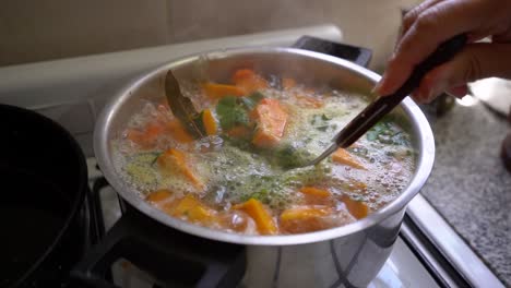 Cooking-And-Stirring-Vegetable-Soup-With-Squash-Using-Fork