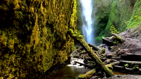 Dolly-out-of-hidden-Mili-Mili-waterfall-falling-into-natural-pool-surrounded-by-dense-green-vegetation,-Coñaripe,-Chile
