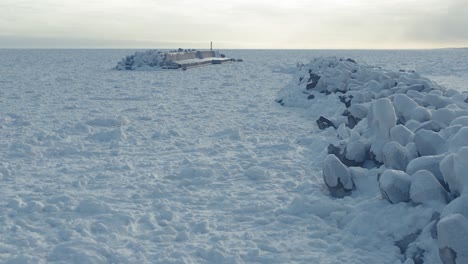 Aerial-Along-Frozen-Covered-Tetrapods-Beside-Drift-Sea-Ice-At-Sawaki-Port,-Hokkaido