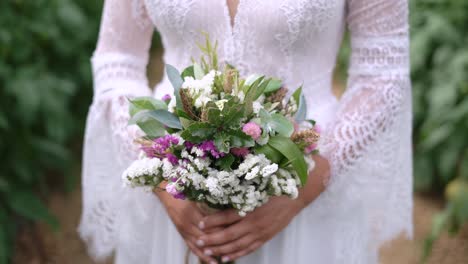 Schöne-Braut,-Die-Wildblumenblumenstrauß-In-Der-Hand-Im-Freien-üppigen-Laubhintergrund-Hält