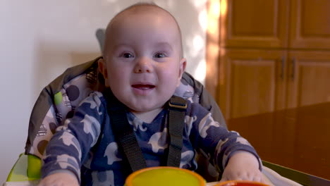 Portrait-of-a-happy-baby-boy-smiling-and-laughing-in-his-high-chair