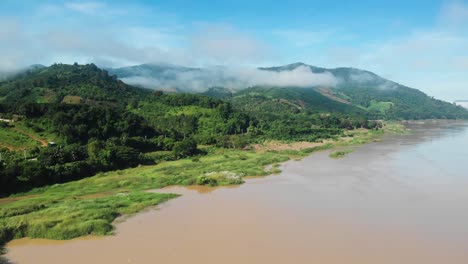 Gran-Río-Que-Fluye-A-Través-De-La-Región-Montañosa-Con-Montañas-Nubladas,-Disparo-De-Drones