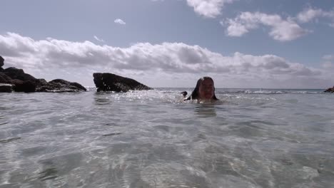 Mujer-Caucásica-Nadando-En-Una-Piscina-De-Agua-Natural-Poco-Profunda