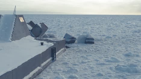 Aerial-Along-Breakwater-Surrounded-By-Frozen-Drift-Sea-Ice-In-Hokkaido