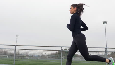 Beautiful-Sporty-Woman-Running-on-Track,-Follow-Shot,-Slow-Motion