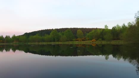 Reflexion-über-Den-See,-Der-Sich-Bei-Sonnenuntergang-Langsam-Vorwärts-Bewegt