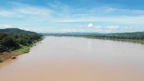 Mekong-River-Bordering-Thailand-and-Laos-in-Chiang-Khan-Loei-Province-on-a-Sunny-Day-with-Blue-Skies,-Drone-Shot