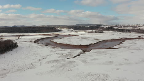 Aerial-view-flying-over-a-frozen,-snow-covered-wetland-marsh-along-the-Atlantic-Coast