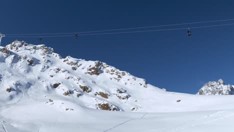 Ski-lifts-high-up-in-the-snowy-mountains-in-Kaunertal,-winter-in-Austria---pan-view