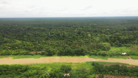 Wide-rotating-drone-shot-with-a-boat-on-the-Amazon-river-and-the-rainforest-surrounding-the-river-in-Peru