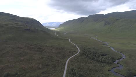 Aerial-push-in-over-the-river-Ossian-heading-North-towards-Loch-Ghuilbinn,-on-a-cloudy-and-moody-day