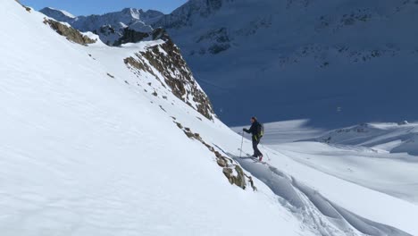 Ski-hiker-trekking-in-steep,-natural-snow-trails-high-altitude-in-the-Alps---static-view