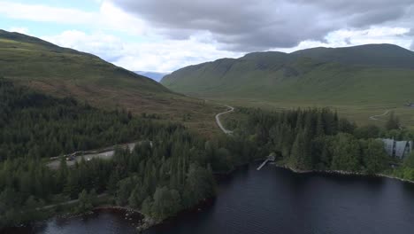 Aerial-pullback-shot-over-Loch-Ossian-looking-North-towards-the-hills-on-a-cloudy-and-moody-day