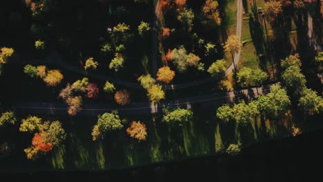 Vogelperspektive-über-Einen-Schmalen-Kiesweg,-Der-An-Einem-Sonnigen-Morgen-Neben-Der-Asphaltstraße-Durch-Einen-Bunten,-Dichten-Wald-In-Litchfield,-Connecticut,-Usa,-Verläuft