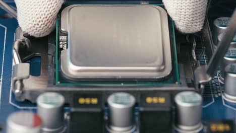 White-gloves-installing-CPU-microchip-processor-into-Motherboard-Socket,-Extreme-close-up