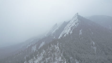 Drohnen-Luftaufnahmen,-Die-Während-Des-Schneesturms-Vom-Schneebedeckten-Flatirons-Mountain-Boulder-Colorado-USA-Zurückfliegen