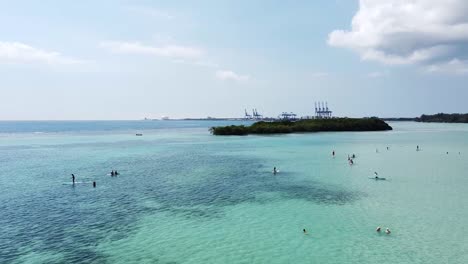 Drone-shot-capturing-group-of-tourists-paddle-surfing-on-beautiful-day-in-boca-chica