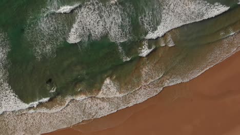 Gentle-waves-run-out-onto-pristine-Malhão-beach,-Portugal