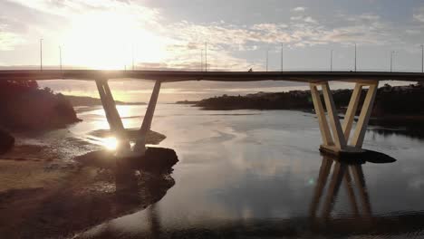 Silhouette-of-single-cyclist-crossing-bridge-over-river