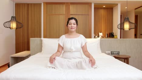 Mujer-Asiática-Está-Practicando-Meditación-En-La-Cama-De-Su-Dormitorio-Durante-Su-Tiempo-De-Relajación-Para-Calmar-Su-Mente