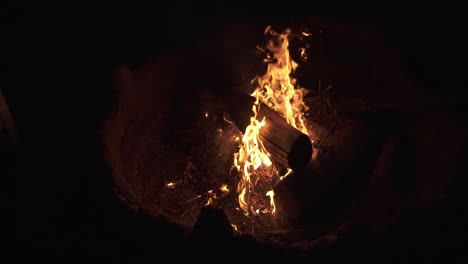 Slow-motion-top-down-shot-of-burning-wood-with-orange-flame---Romantic-Bonfire-in-wilderness