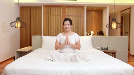 Asiatische-Frau-übt-Während-Ihrer-Entspannungszeit-Meditation-Auf-Ihrem-Schlafzimmerbett,-Um-Ihren-Geist-Zu-Beruhigen
