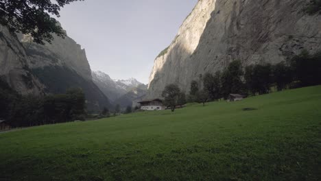 Gehen-Sie-Mit-Der-Kamera-Auf-Eine-Frau-Zu,-Die-Am-Frühen-Morgen-In-Der-Schweiz-über-Das-Bergtal-Lauterbrunnen-Blickt-4k