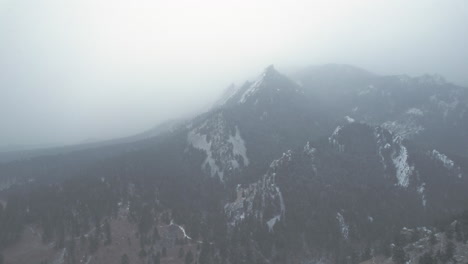 Drone-Aerial-Footage-Near-Snowcapped-Pine-Tree-Flatirons-Mountain-Near-Boulder-Colorado-USA-During-Foggy-Snowstorm-Blizzard