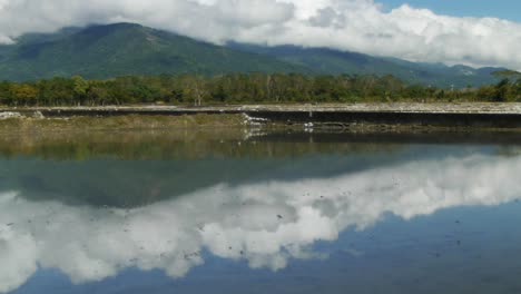 Bewölkte-Berge,-Die-Von-überfluteten-Reisfeldern-Reflektiert-Werden