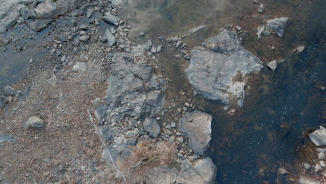 Aerial-Tracking-Above-River-Slowly-Flowing-Through-Rocky-Riverbed,-USA